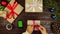 Top view hands wrapping christmas presents at wooden desk from above