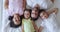 Top view of happy faces of young family lying on white surface and rejoicing joyfully. Happy family time concept. Video