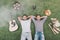 Top view of happy young men resting on grass with guitar and food for picnic