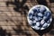 Top view of harvest of damsons plums in the bowl, wooden table.Natural ligth.Empty space