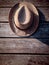 Top view of hat on the wood background. A straw hat hanging on a nail on a wooden wall. Vertical image