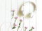 Top view headphones on white desk with pink flower and copyspace area for a text