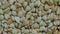 Top view: heap of uncooked green buckwheat groats on rotating surface - close up