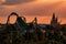 Top view of Hogwarts Castle and The Incredible Hulk rollercoaster on colorful sunset sky background at Universal Studios area.