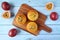 Top View of Homemade Passion Fruit Muffins on Breadboard with Fresh Ripe Passion Fruits Scattered on Wooden Table