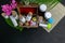 Top view of homeopathic medicine bottles, scattered pills with pink flower and wild fruit in wooden old box, burlap and green leaf