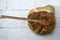 Top view of honey dripping from a honey dipper on fresh bread on wooden table