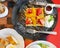 Top view of honey waffle with strawberry and peach and icing sprinkle in black plate on red table background