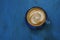 Top view of hot coffee cappuccino cup on blue painted wood table