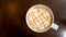 Top view of hot coffee latte art caramel foam in ceramic cup on wooden backgound