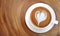 Top view of hot coffee latte art heart shape foam on wood table