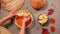 Top view housewife's hands spreading apple slices in a circle on top of pumpkin puree in rolled out dough in baking