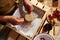 Top view. Housewife ties bow on the burlap of a lid, ornates a jar of homemade delicious jelly from red currant berries