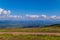 The top view of the huge gently sloping green mountain ranges and the blue boundless sky