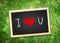 Top view of I love you word on chalkboard lay on green grass,Love concept.