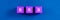 Top view image of BRB spelled on violet wooden dices. Over blue background