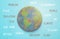 Top view image of cardboard earth globe with environmental text over blue wooden background.