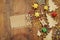 Top view image of christmas festive decorations next to empty note on old wooden background