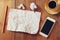 Top view image of crumpled blank paper, cup of coffee and smartphone over wooden table