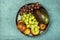 Top view image of fruit bowl with red apples, bunches of white and red grapes and African mango