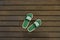 Top view image of green sandals on floor planks of an urban