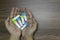 Top view image of a man hands holding bottle of homeopathic pills on wooden background