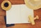 Top view image of open notebook with blank pages, cup of coffee wicker hat and wooden aeroplane over wooden table. ready for