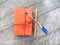 Top view image of orange vintage notebook with pen and pencil on wooden table. Diary writing concept. Flat lay