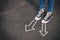 top view image of person in jeans and retro shoes standing over asphalt road with painted arrows showing different directions.