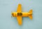 Top view image of retro yellow metal toy airplane over blue background.