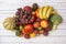 Top view image of seasonal fruits and vegetables with red tomatoes, red grapes, melon and watermelons, red