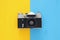 Top view image of vintage photo camera over double colorful background.