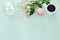 Top view image of white cup of coffee, perfume, white pearls and colorful macaron or macaroon over pastel wooden background.