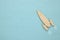 Top view image of wooden rocket toy over pastel background.