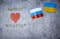 top view of the inscriptions Russia and Ukraine,flags of the two countries on a concrete background,red heart,a place for text,