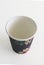 Top view. Isolated black takeaway disposable cup painted with Caribbean flowers on white background