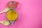 Top view on isolated glass preserving jar with turmeric powder and two wood spoons, pink background. copy space for text. focus