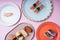 Top view - Japanese sushi variety set on plates over pink background