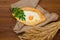 Top view of khachapuri with egg on sackcloth and wooden table