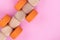 Top view on kids educational game on light pink paper background. Wooden train made from cubes, orange circles. Close up