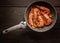 Top view King shrimps fried in a ceramic pan on a dark wooden table