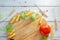 Top view of kitchen board with raw ingredients of italian tortiglioni pasta.