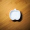 Top view of kitchenware, single white ceramic bowl of apple shape design on wood dining table background
