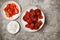 Top view Korean spicy fried chicken with side dishes on gray concrete table.