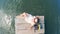 Top view of a lady relaxing while sitting on a wooden quay