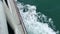 Top view from large ferry in the sea. Ship makes the water into beautiful waves and wakes. Slowmotion video background