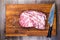 Top view of a large piece of fresh quality pork meat on a cutting oak board.