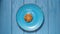 TOP VIEW: Last oatmeal cookie on a blue plate on a blue table