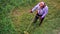 Top view lawnmover man worker cutting dry grass with lawn mower