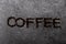 Top view of lettering `coffee` with ground coffee in the middle of the picture on background